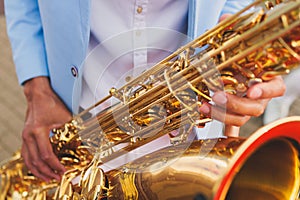 Concert view of saxophonist in a blue and white suit, a saxophone sax player with vocalist and musical band during jazz orchestra