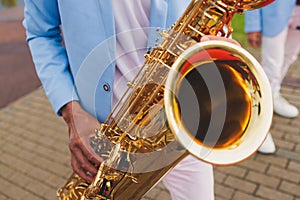 Concert view of saxophonist in a blue and white suit, a saxophone sax player with vocalist and musical band during jazz orchestra