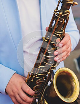 Concert view of saxophonist in a blue and white suit, a saxophone sax player with vocalist and musical band during jazz orchestra