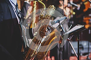 Concert view of a saxophonist, saxophone player with vocalist and musical during jazz band orchestra performing music on stage