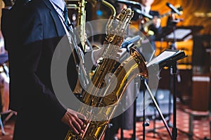 Concert view of a saxophonist, saxophone player with vocalist and musical during jazz band orchestra performing music on stage