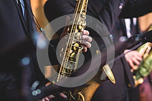 Concert view of a saxophonist, saxophone player with vocalist and musical during jazz band orchestra performing music on stage