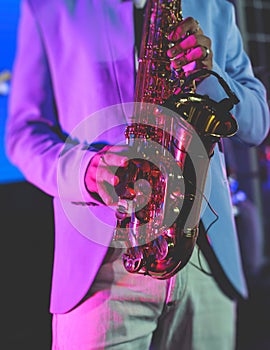 Concert view of saxophonist, a saxophone sax player with vocalist and musical band during jazz orchestra show performing music on