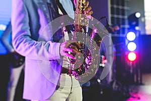 Concert view of saxophonist, a saxophone sax player with vocalist and musical band during jazz orchestra show performing music on