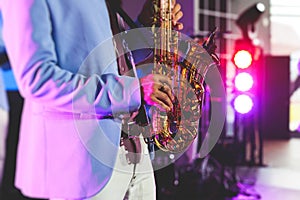 Concert view of saxophonist, a saxophone sax player with vocalist and musical band during jazz orchestra show performing music on