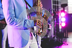 Concert view of saxophonist, a saxophone sax player with vocalist and musical band during jazz orchestra show performing music on