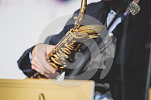 Concert view of saxophonist, a saxophone sax player with vocalist and musical band during jazz orchestra show performing music on