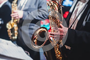 Concert view of a saxophonist, saxophone sax player with vocalist and musical during jazz orchestra performing music on stage