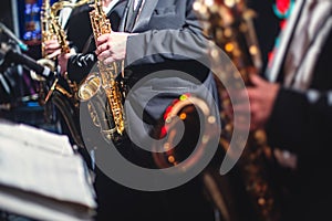 Concert view of a saxophonist, saxophone sax player with vocalist and musical during jazz orchestra performing music on stage