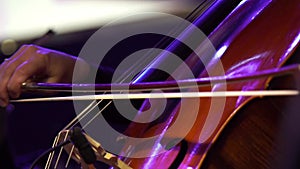 Concert, a woman musician hand pinching the strings cello, hand close up.