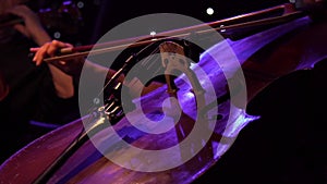 Concert, a woman musician hand playing the cello on stage, hand close up.