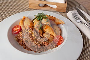 Conchiglia Bolognese on a white plate. Concept: traditional Italian food photo