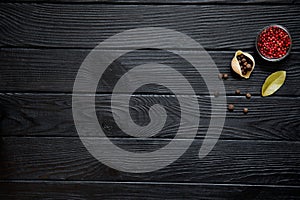 Conchiglie with red pepper, bay leaf and allspice on rustic black wooden background. Ingredients for italian cuisine, top view.