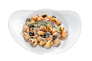 Conchiglie rigate italian pasta with tomato, olives, capers, anchovies. Isolated on white background. Top view.
