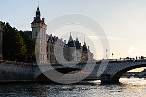 The conciergerie and the bridge Pont au Change seen from the seine river in Paris France at sunset