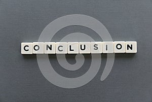 Conclusion word made of square letter word on grey background.