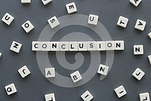 Conclusion word made of square letter word on grey background.