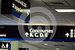 Concourse sign and directional arrows at an airport