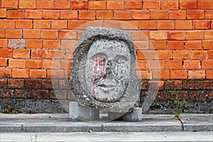 Concrete artifact along the city street with a brick wall background.