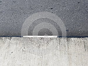 Concrete and asphalt demarcation line. Median on a road, rough cement texture photo