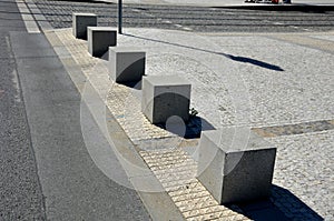 Concrete barriers as protection of a nice lawn cube cubes on a paved sidewalk platform of a tram protected from the entry of cars