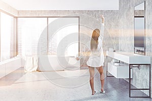 Concrete bathroom interior, tub and sink, woman