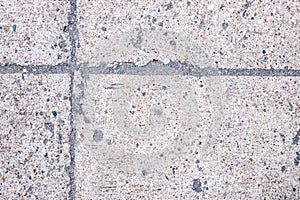 Concrete blocks with joints. Asphalt road top view. Old grungy concrete with stone pebble relief. Grungy concrete