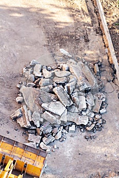 Concrete and brick rubble debris with excavator bucket construction site top view.