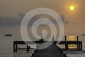 Concrete bridge piers and eflection of the sun in the sea