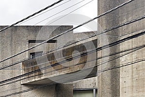 concrete building with overhead powerlines in front