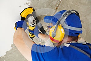 Concrete ceiling surface grinding by angle grinder machine photo