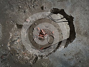 Concrete construction, hole in the floor, broken bricks and concrete debris on the floor below