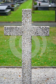 Concrete cross on a grave. Historic graveyard.