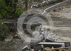 Concrete curb installation. String line level guide is stretched parallel to the line of course. Sidewalk pavement renewal. Road i