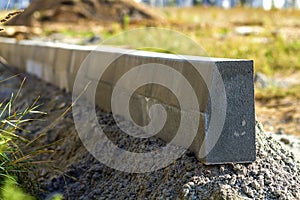 Concrete curb installation works at road construction site. Shallow DOF.