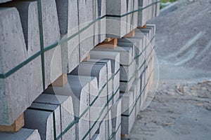 Concrete curbs on wooden pallets stand on the street during street repair. Road works, sidewalk repair