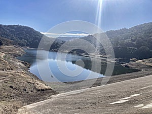 Concrete dam of almost dried, low water level Guadalupe Reservoir reservoir in San Francisco Bay Area, California