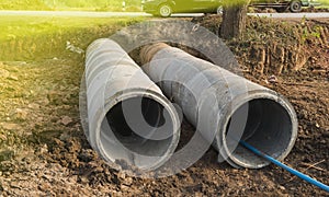 Concrete drainage pipe for drain water under the road at Construction Site .Concrete stacked sewage water system aligned on site.