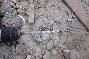 Concrete drill over rubble and broken glass