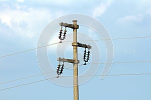 Concrete electrical power line utility pole with ceramic insulators and three connected wires