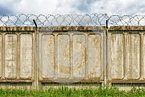 Concrete fence with barbed wire