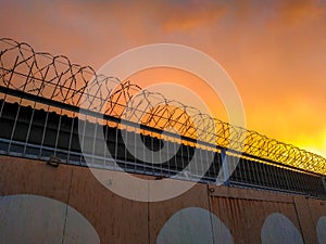 Concrete fence with barbed wire against the sky. Prison concept