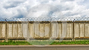 Concrete fence with barbed wire