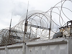 Concrete fence with barbed wire at the top. Closed area protected from intrusion