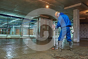 Concrete floor construction. Worker with line