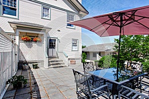 Concrete floor cozy patio area with table set and patio umbrella.