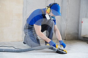 Concrete floor surface grinding by angle grinder machine photo