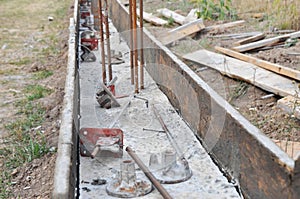 Concrete footing construction. Pouring concrete in wooden board form of the concrete foundation with rebar reinforcement