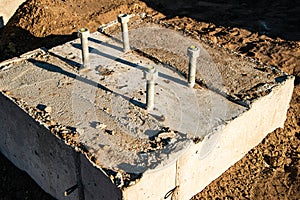 Concrete footings with anchor bolts.