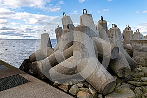 Concrete fortifications in the seaport. Tetrapods stacked on the edge of a breakwater in Central Europe